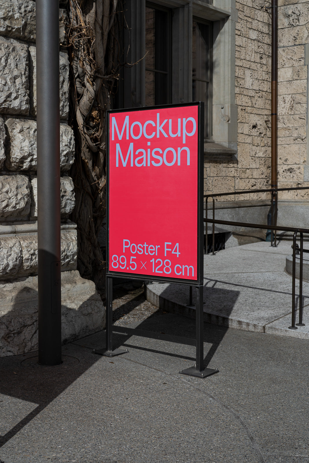 PSD mockup of an outdoor poster stand on a sunny sidewalk, displaying "Mockup Maison" in white text on a red background with poster size details.