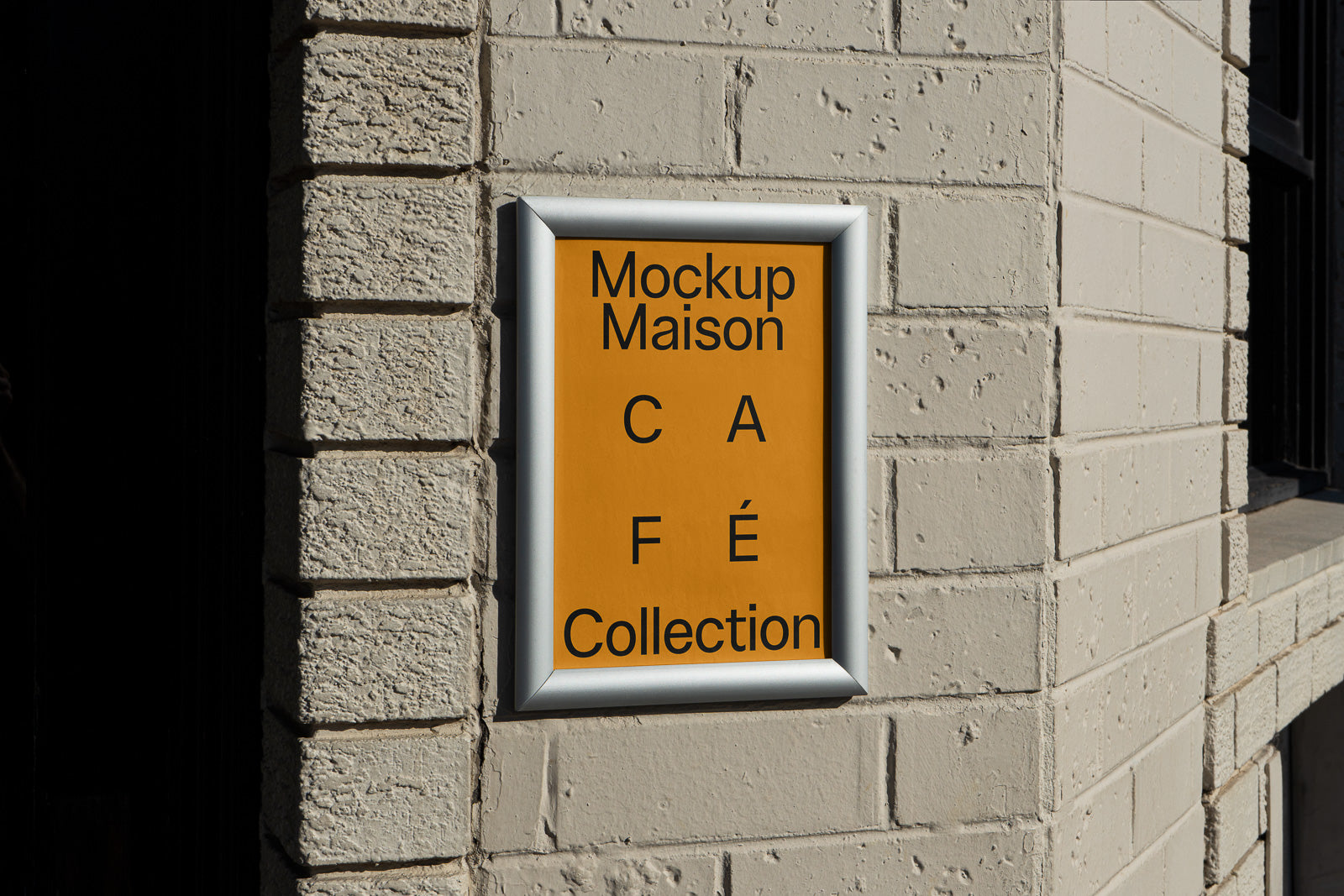 PSD mockup of a framed cafe sign with "Mockup Maison Café Collection" on a yellow background, mounted on a textured brick wall.