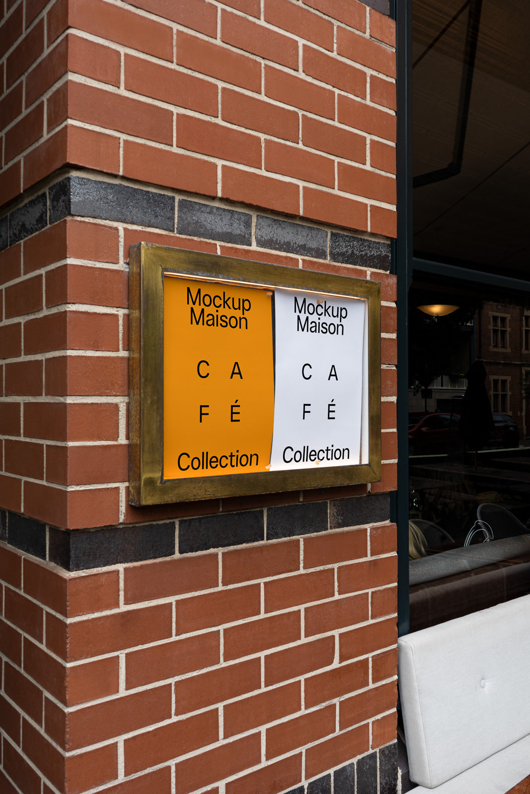 PSD mockup of a brick wall with two posters reading "Mockup Maison Café Collection" in a gold frame, located near a window displaying urban reflections.