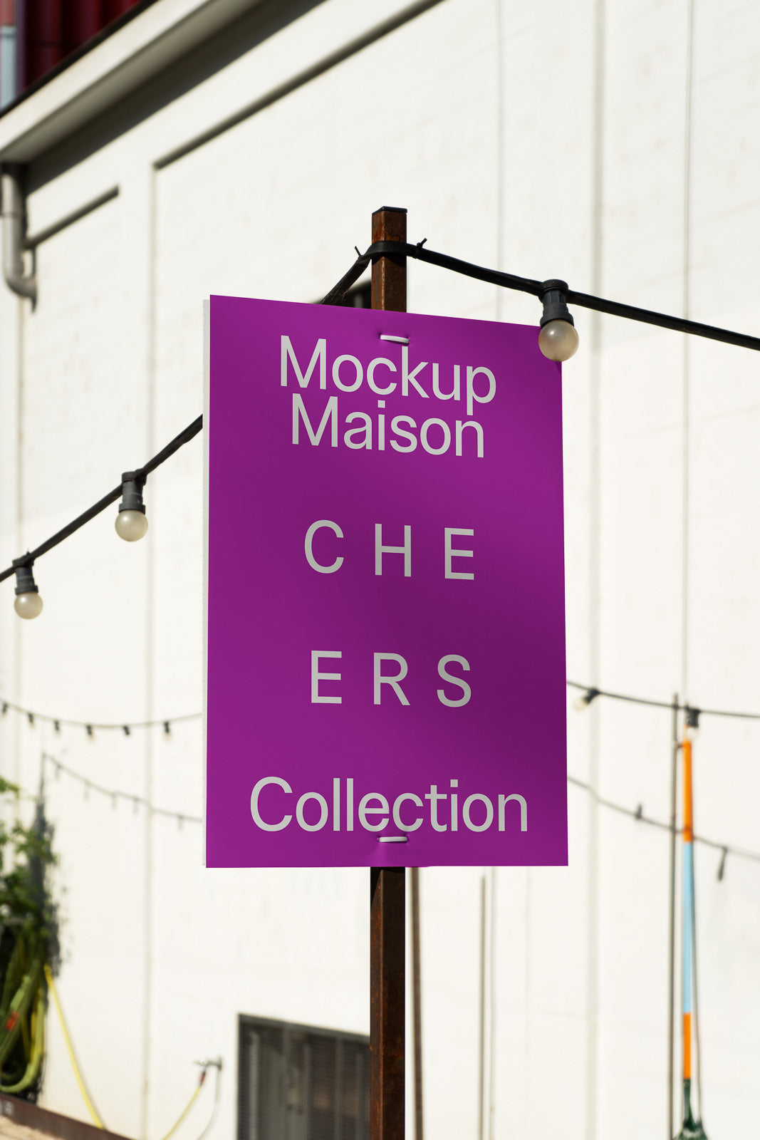PSD mockup of a purple outdoor sign with "Mockup Maison CHEERS Collection" displayed in white text, against a blurred urban backdrop.