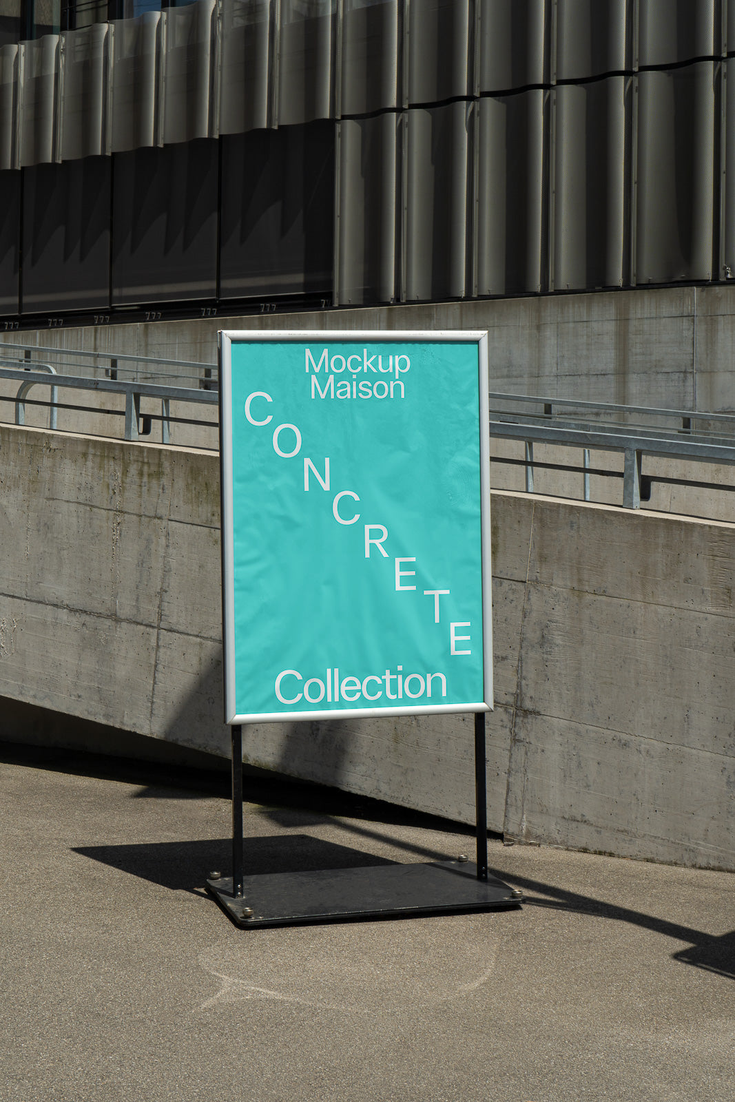 PSD mockup of a framed poster on a metal stand with a turquoise background, featuring diagonal text stating "Concrete Collection" in a modern urban setting.