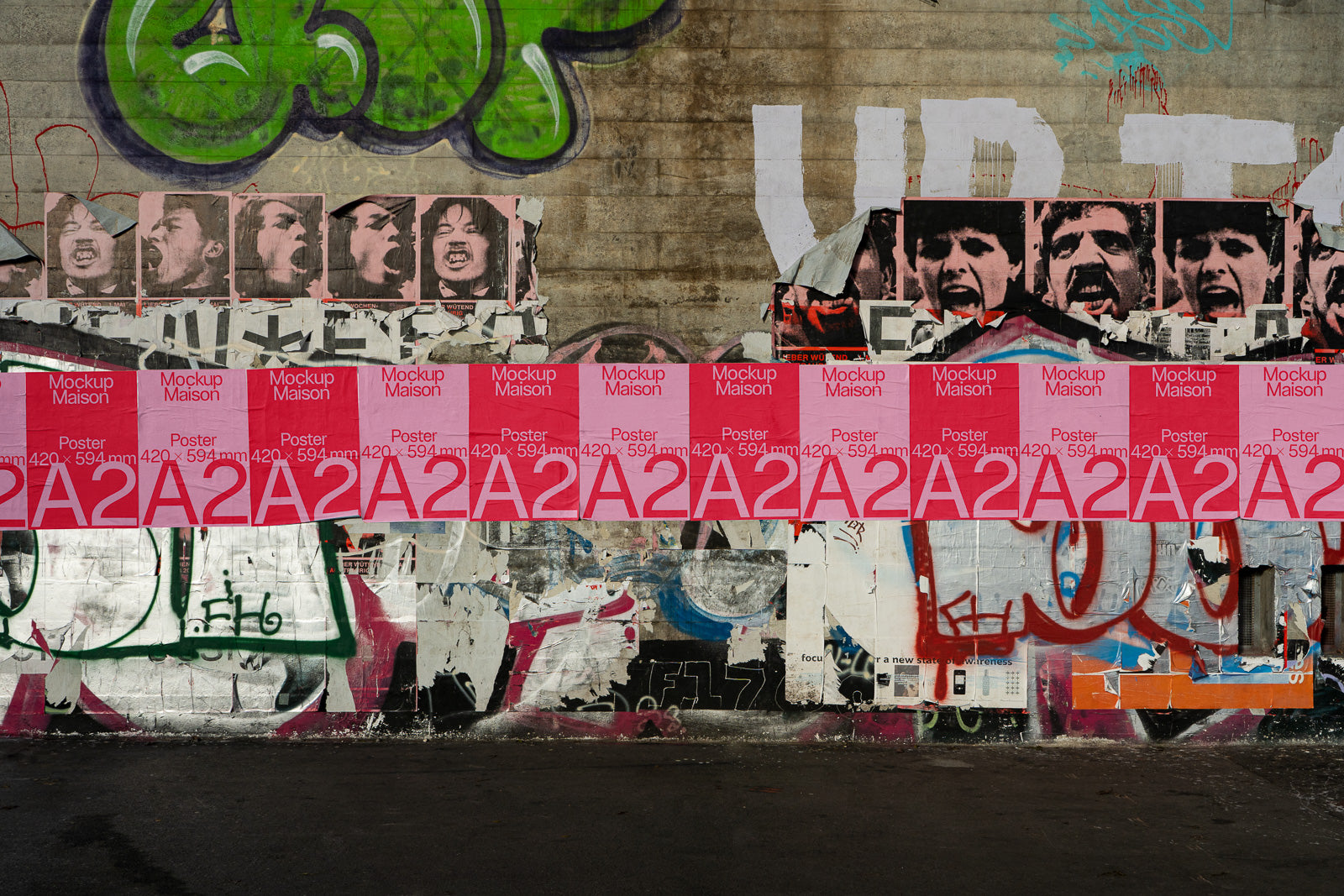 PSD mockup of pink posters displayed against a graffiti-covered wall featuring illustrated faces and urban street art elements.