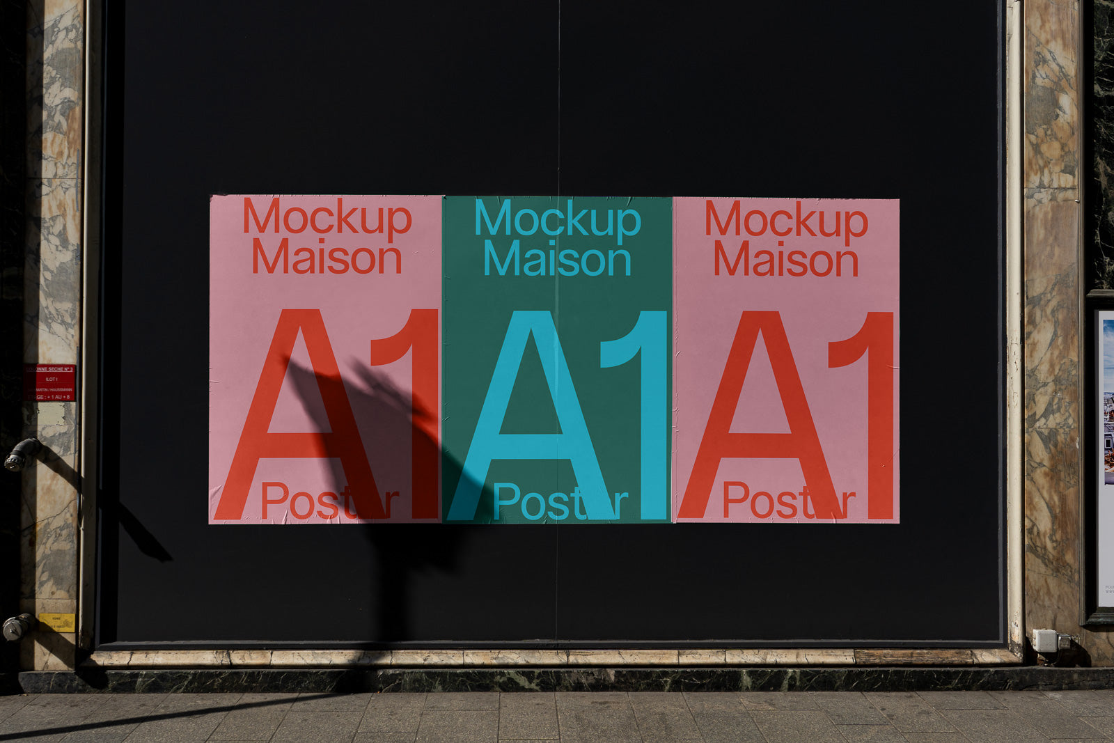 PSD mockup of a street poster display featuring three large posters in pink and teal with the text "Mockup Maison A1 Poster" against a dark background.