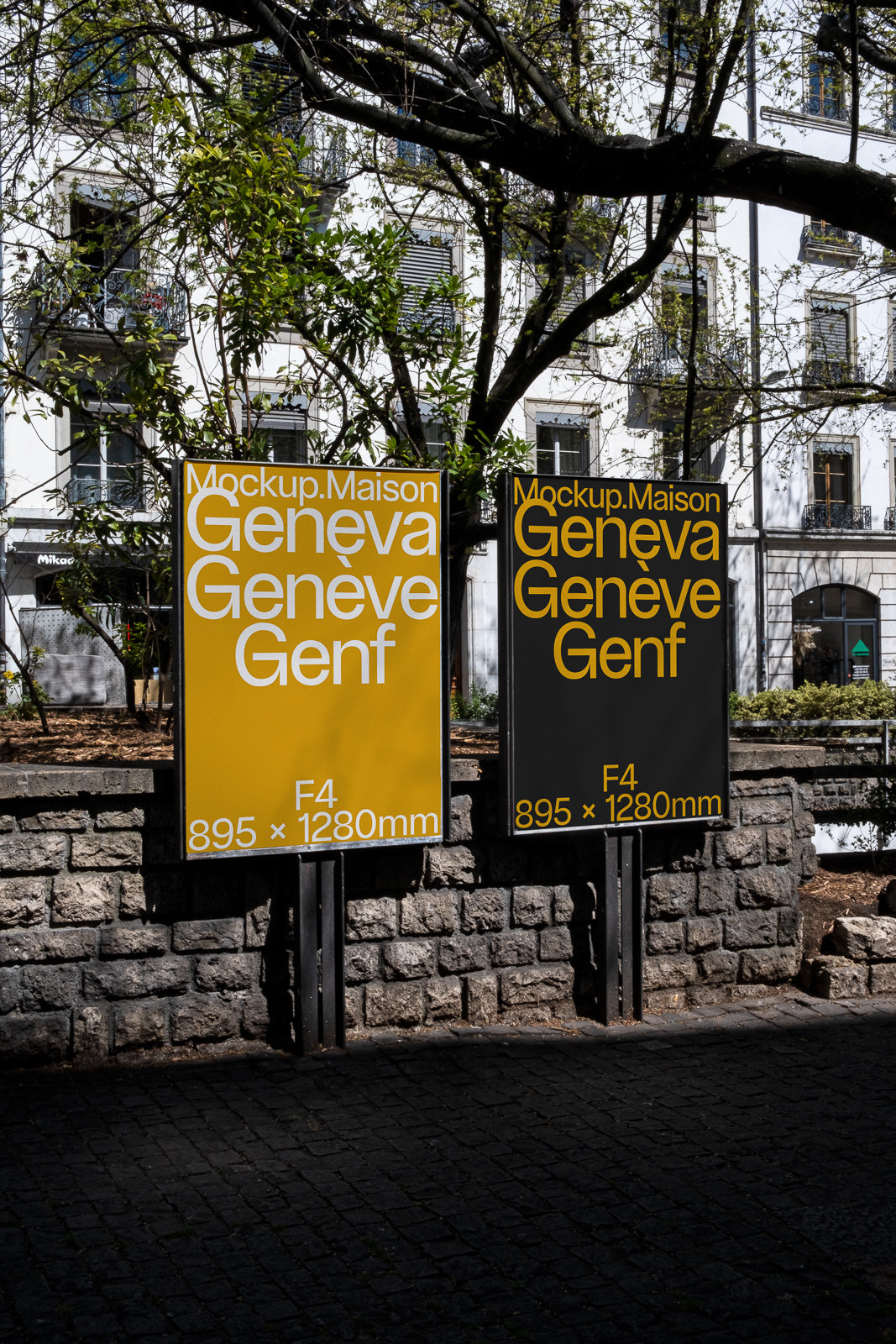 PSD mockup of two outdoor posters displayed on stands against a stone wall, featuring the text "Geneva" in bold letters with measurements 895 x 1280mm.