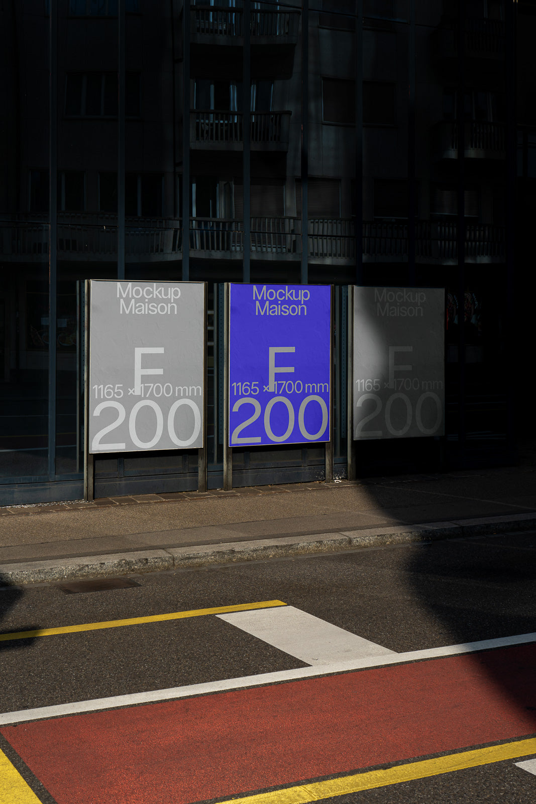 PSD mockup of three vertically aligned poster frames on a city street, featuring varying poster designs with text "Mockup Maison" and size measurements.