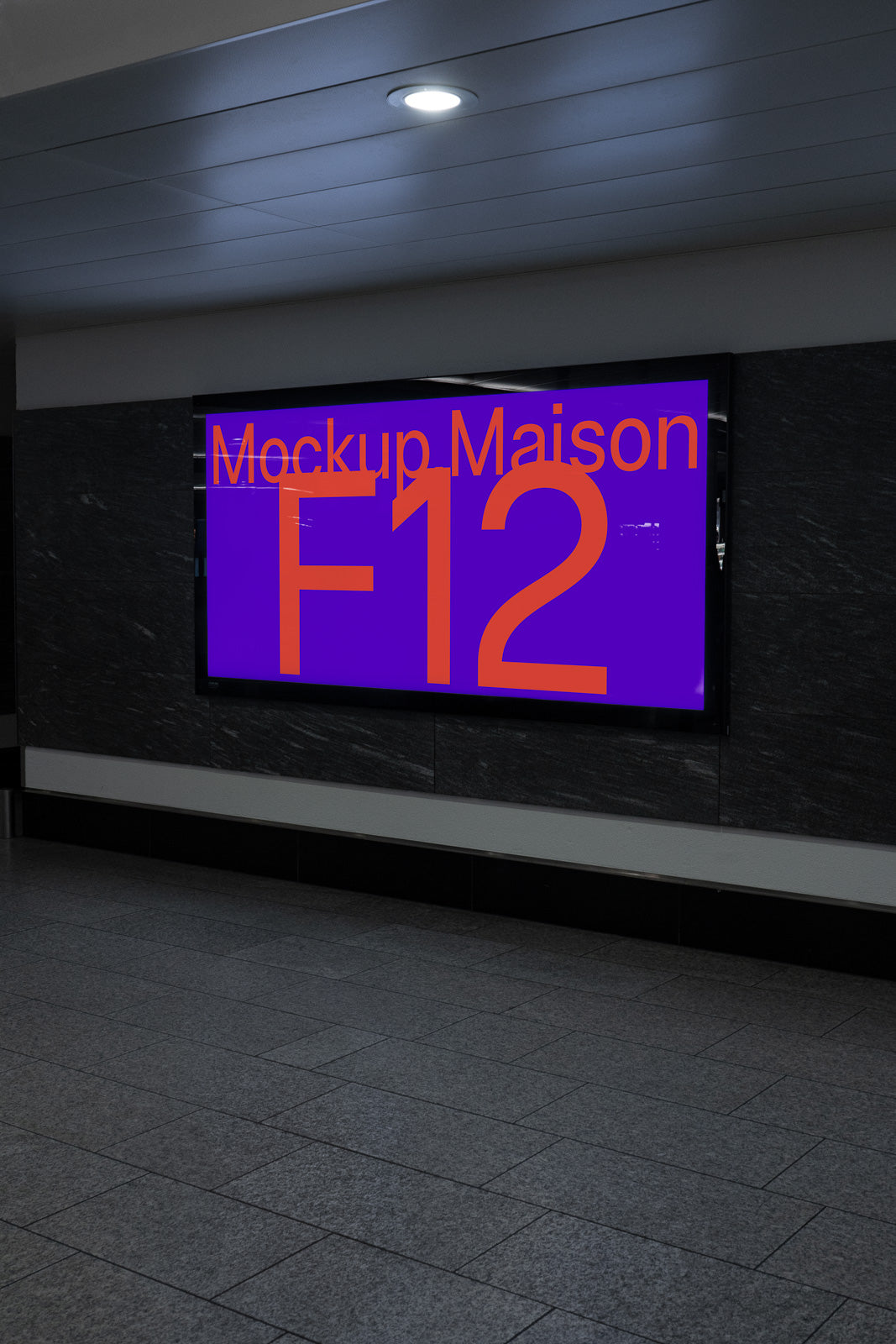 PSD mockup of a digital display screen in a dimly lit hallway, showcasing "Mockup Maison F12" in large red text on a purple background.
