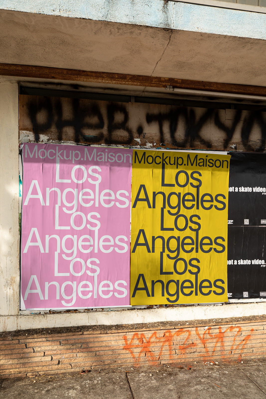 PSD mockup of two posters on an urban wall, one pink and one yellow, both displaying the text "Los Angeles" in bold letters.