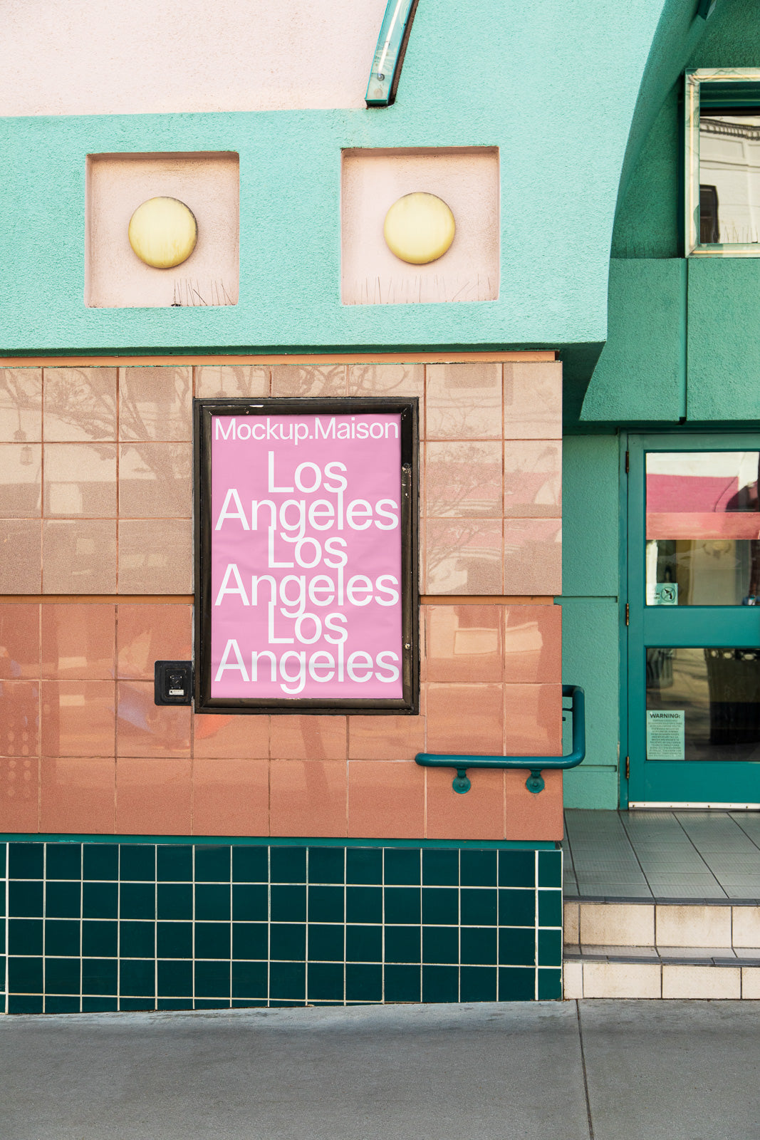 PSD mockup of a colorful building facade with a pink poster displaying "Los Angeles" multiple times, framed by teal tiles and unique architectural elements.