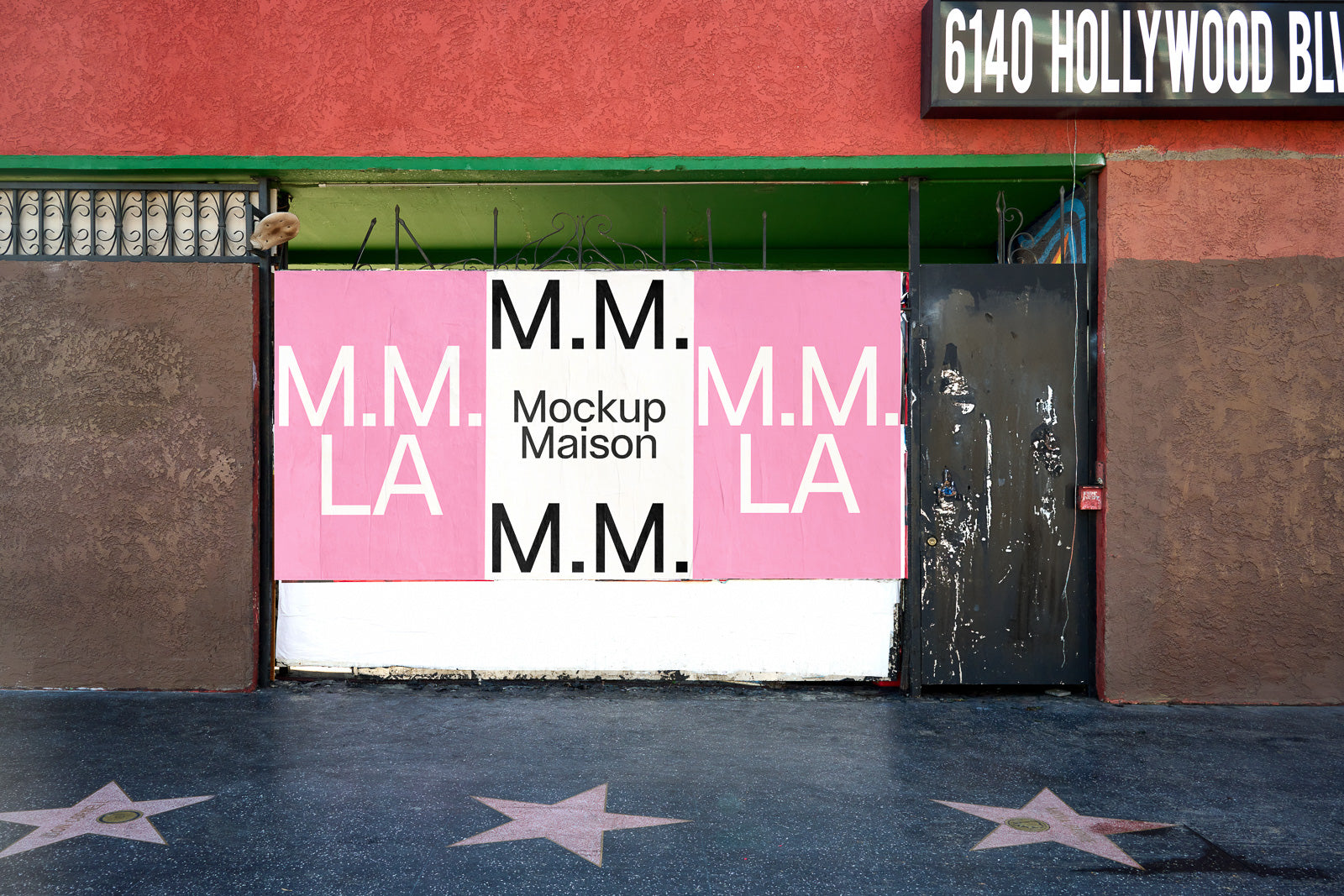 PSD mockup of a storefront wrapped with posters labeled "M.M. LA" and "Mockup Maison" in white text on pink and white backgrounds, located on a star-lined sidewalk.