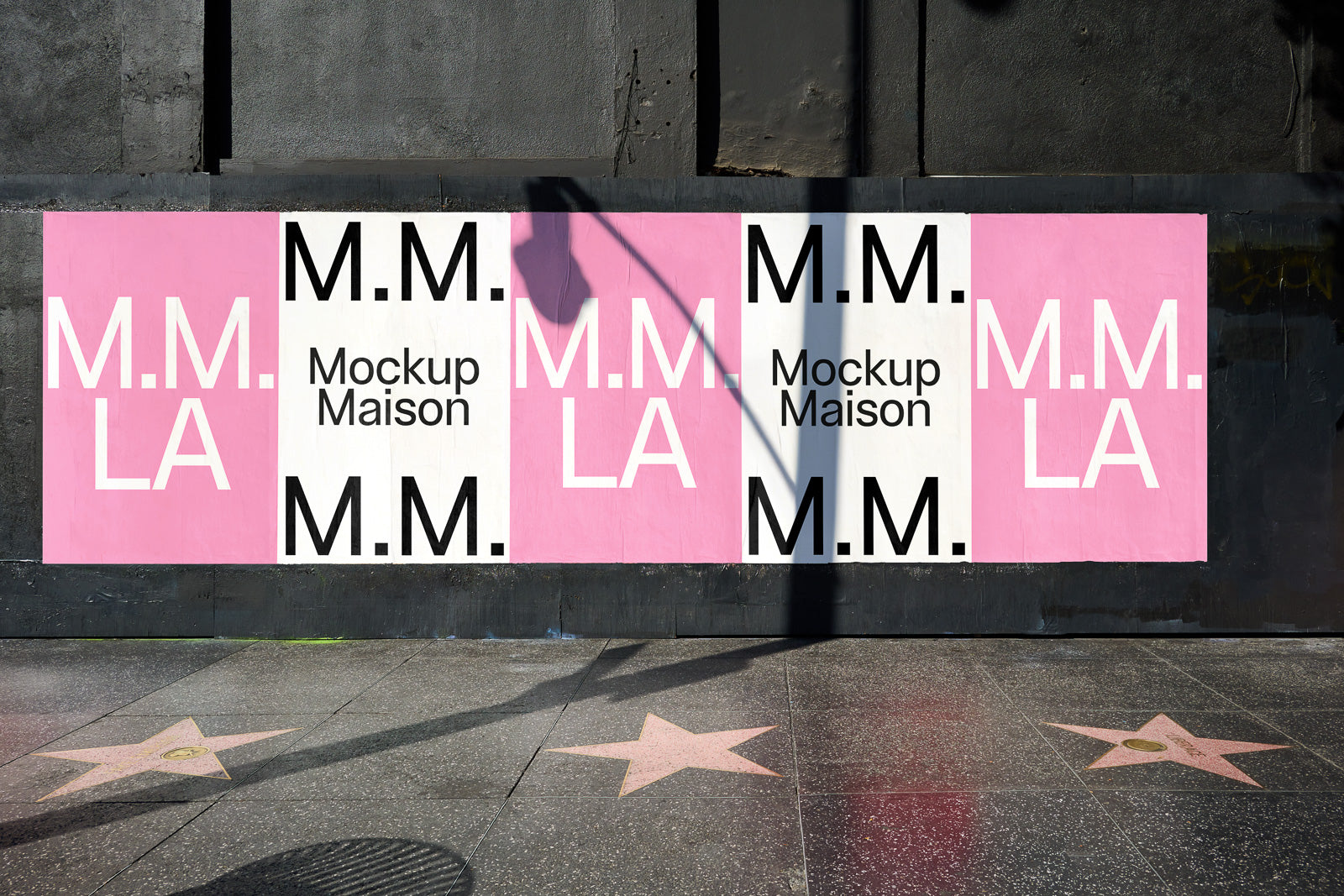 PSD mockup of a street poster wall display featuring the text "M.M. LA" in bold black and pink on a textured urban background.