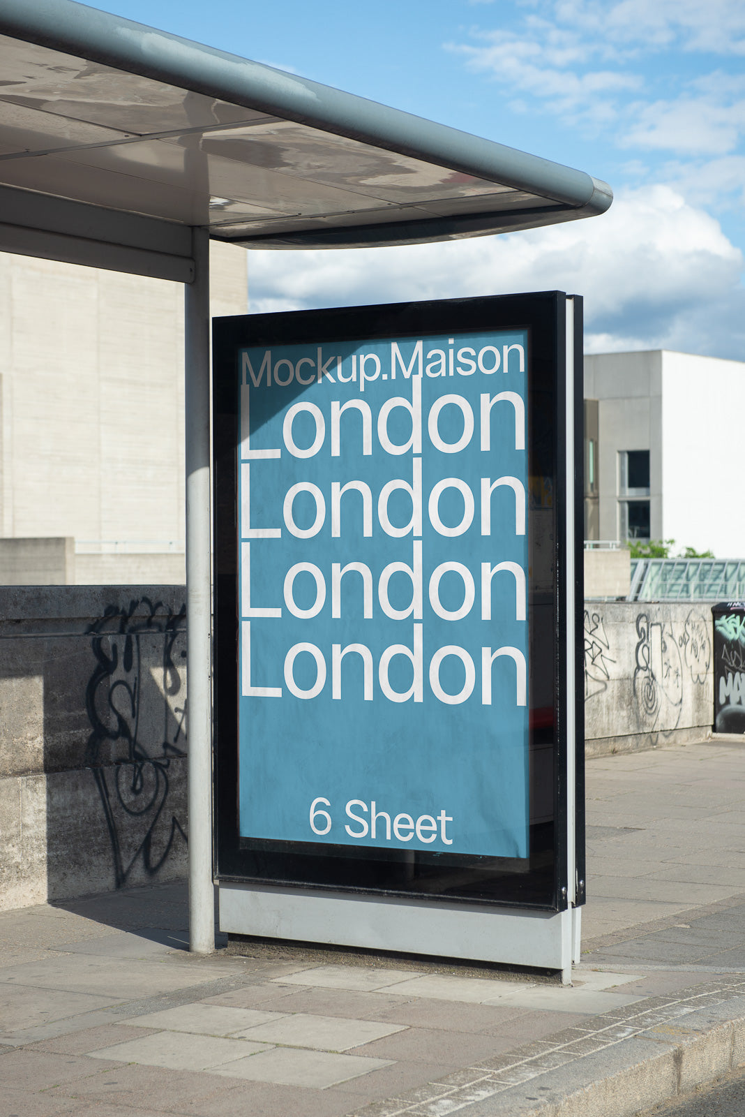 PSD mockup of a bus stop advertisement with the text "London" repeated on a blue background, situated in an urban environment with graffiti in the background.