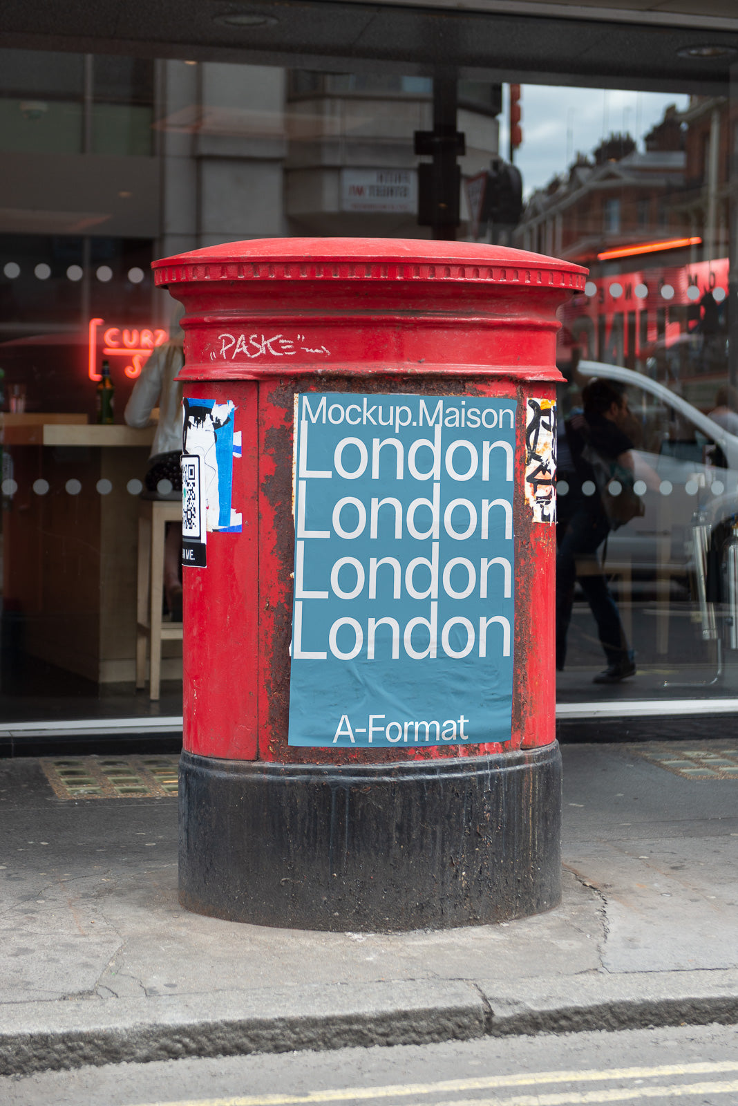 PSD mockup of a red postbox with a blue poster featuring repeated text "London" outside a storefront under a cloudy sky.