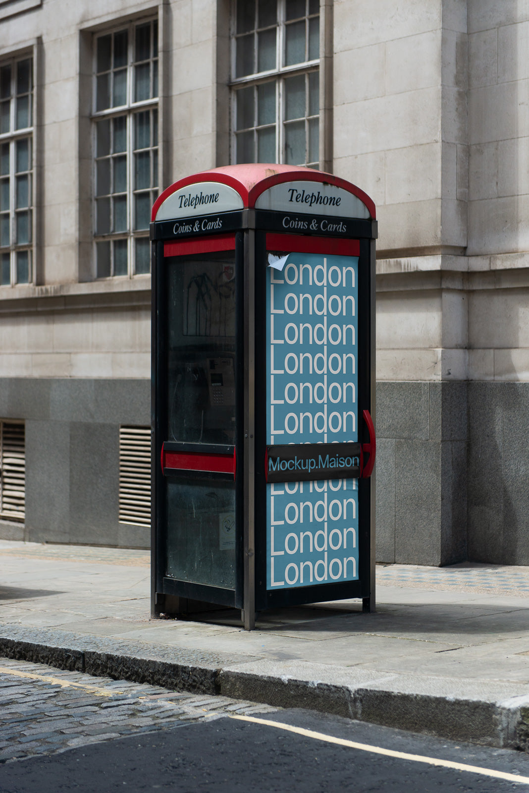 PSD mockup of a classic red telephone booth in an urban setting, featuring a poster with the repeated word "London" on its side, next to a stone building.
