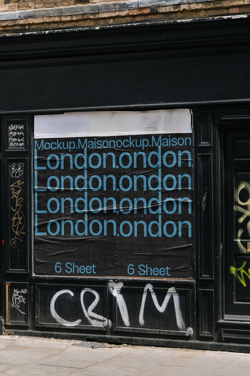 PSD mockup of a poster displayed on a wall. The poster features repeated text "London" and "6 Sheet" in blue on a black background with surrounding graffiti elements.