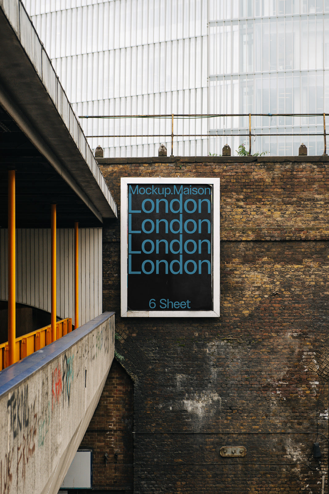 PSD mockup of an urban wall poster with repeated "London" text in blue, displayed on a brick background beside a concrete walkway with orange railings.