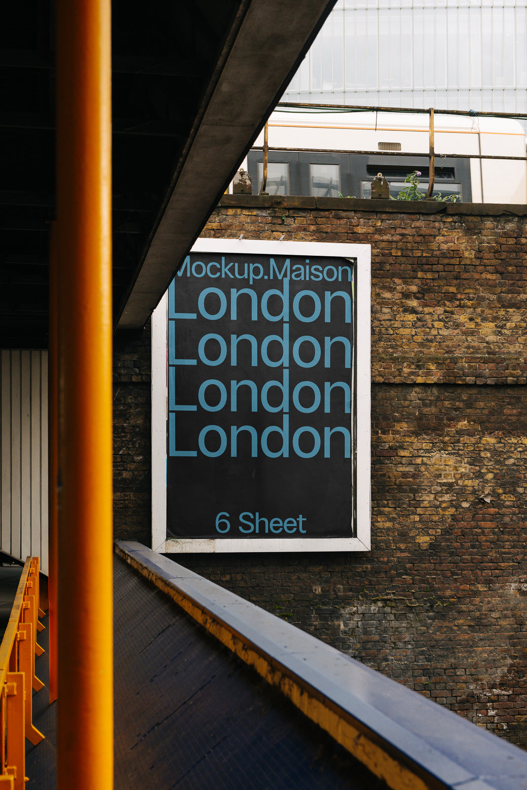 PSD mockup of a large outdoor billboard displaying the repeated text "London" in blue on a black background, set against a brick wall backdrop.