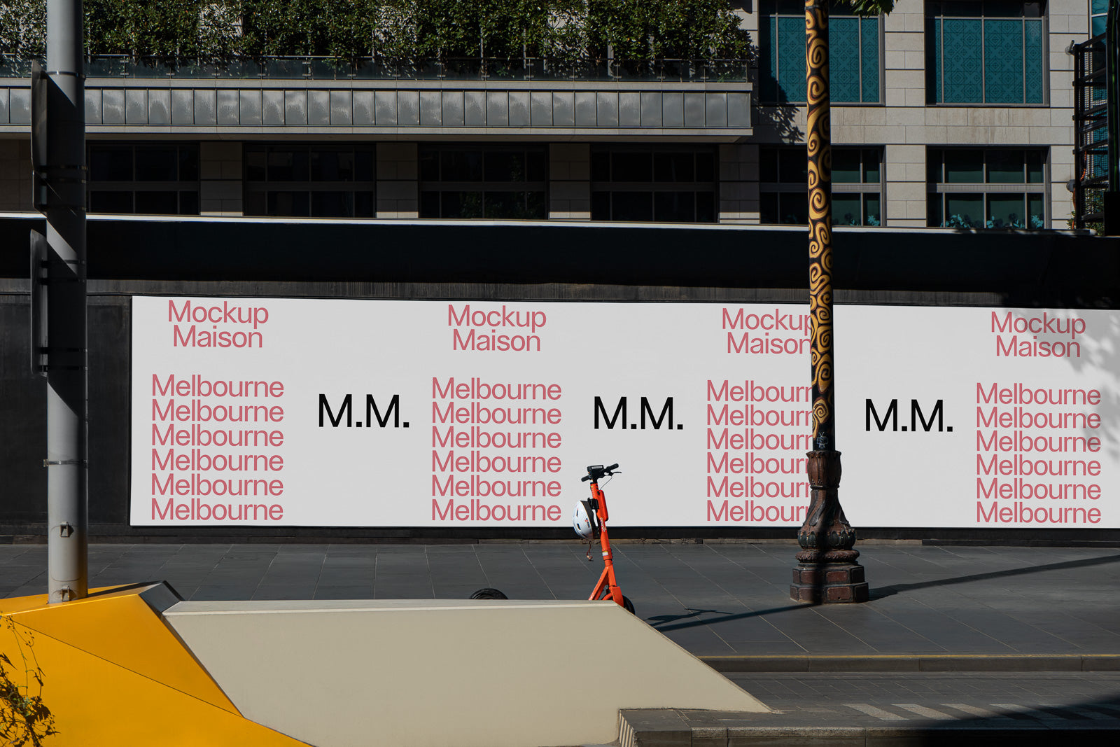 PSD mockup of an urban billboard displaying text "Mockup Maison" and "Melbourne" in a repeating pattern with "M.M." in bold, situated on a city street.