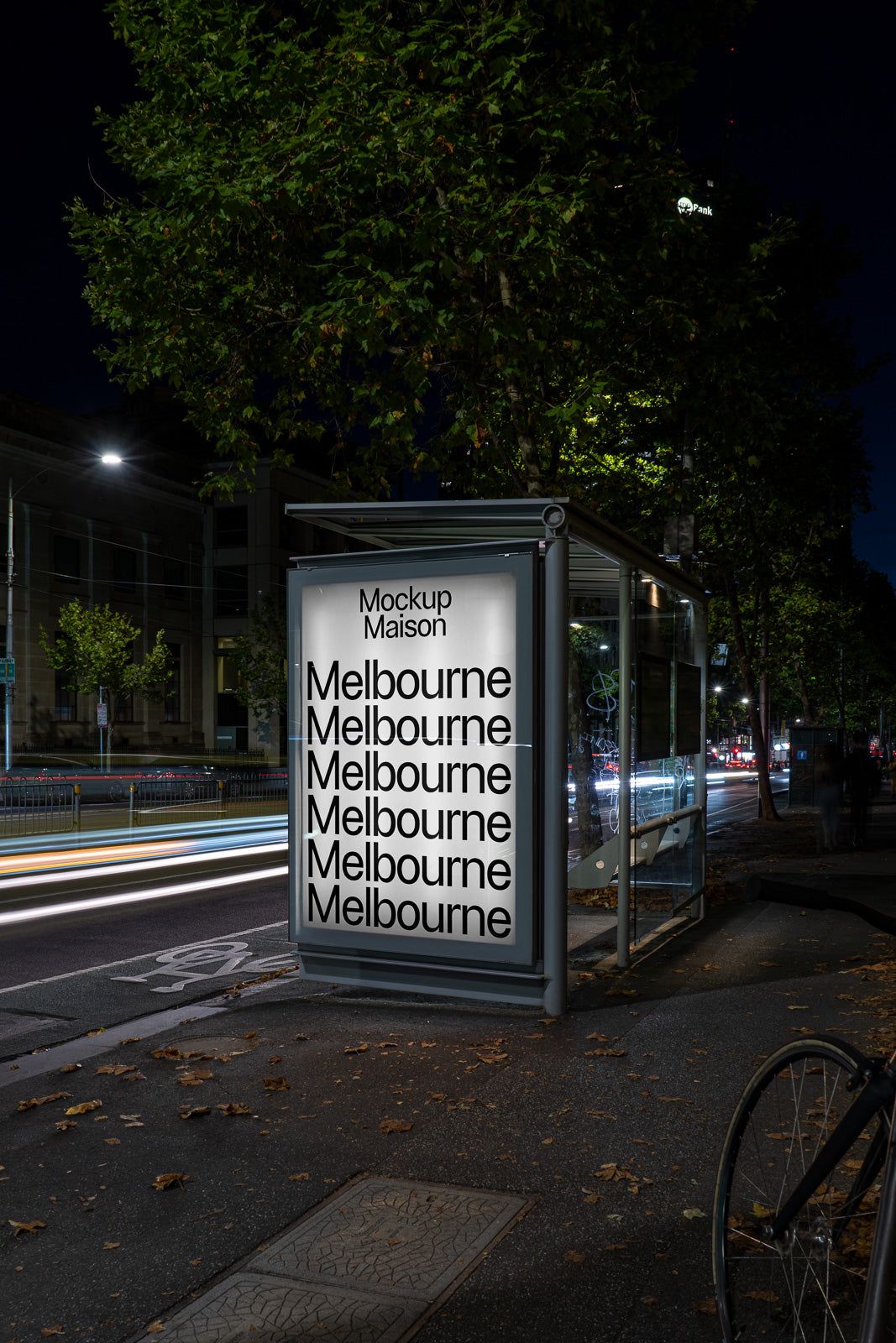 PSD mockup of an illuminated bus stop ad in an urban night setting, showcasing repeated "Melbourne" text in bold, large font.