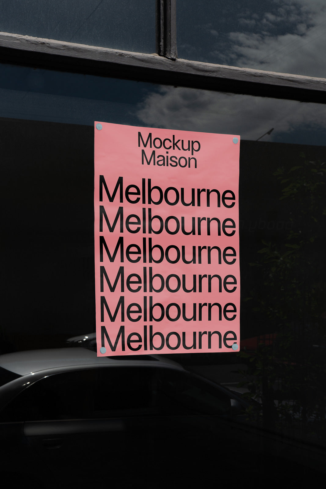 PSD mockup of a pink poster with black text reading "Melbourne" repeated, titled "Mockup Maison," displayed on a reflective window surface.