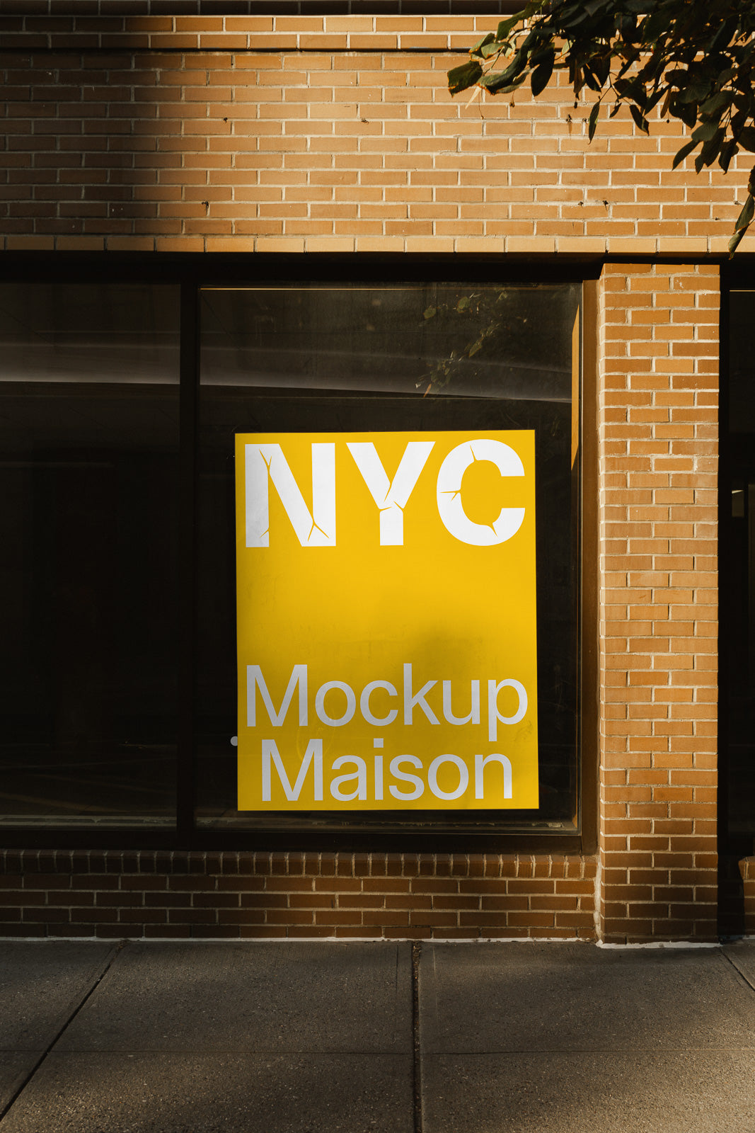 PSD mockup of a large yellow poster displayed in a brick building window, featuring bold white text "NYC Mockup Maison."