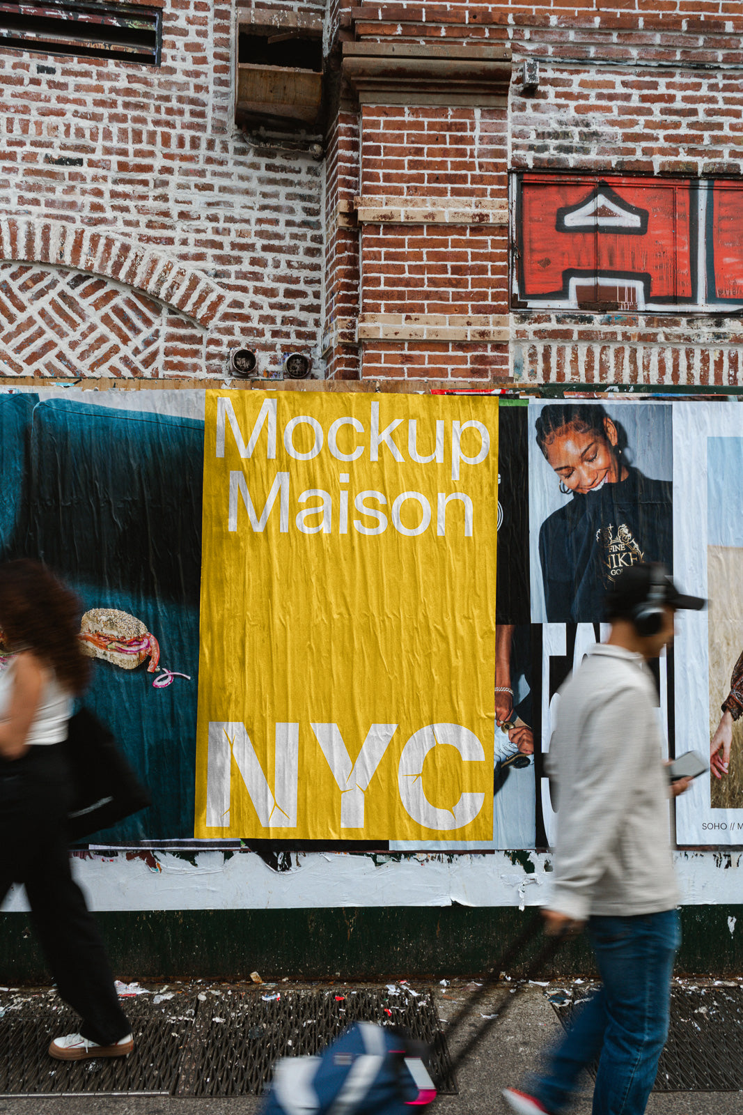 PSD mockup of posters on a brick wall, featuring bold yellow and white text, with people walking past, adding dynamic movement to the scene.