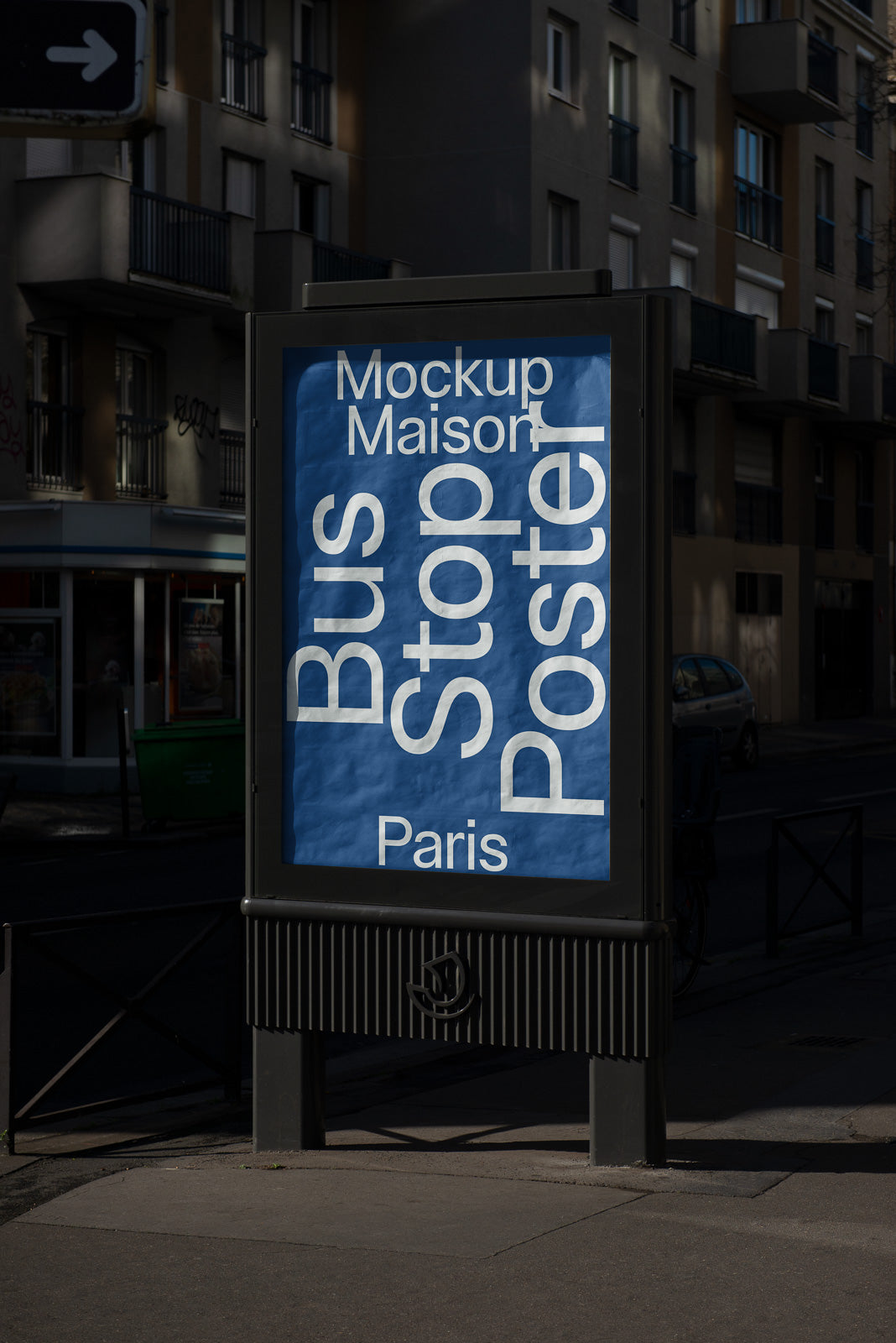 PSD mockup of a bus stop poster in an urban setting with a blue background featuring bold white typography, located in Paris, with residential buildings in the background.