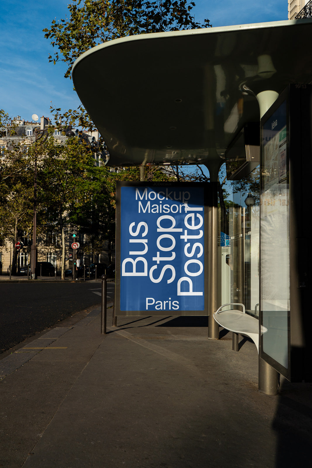 PSD mockup of an outdoor bus stop in Paris, featuring a large vertical poster with "Bus Stop Poster Paris" text against a blue background.