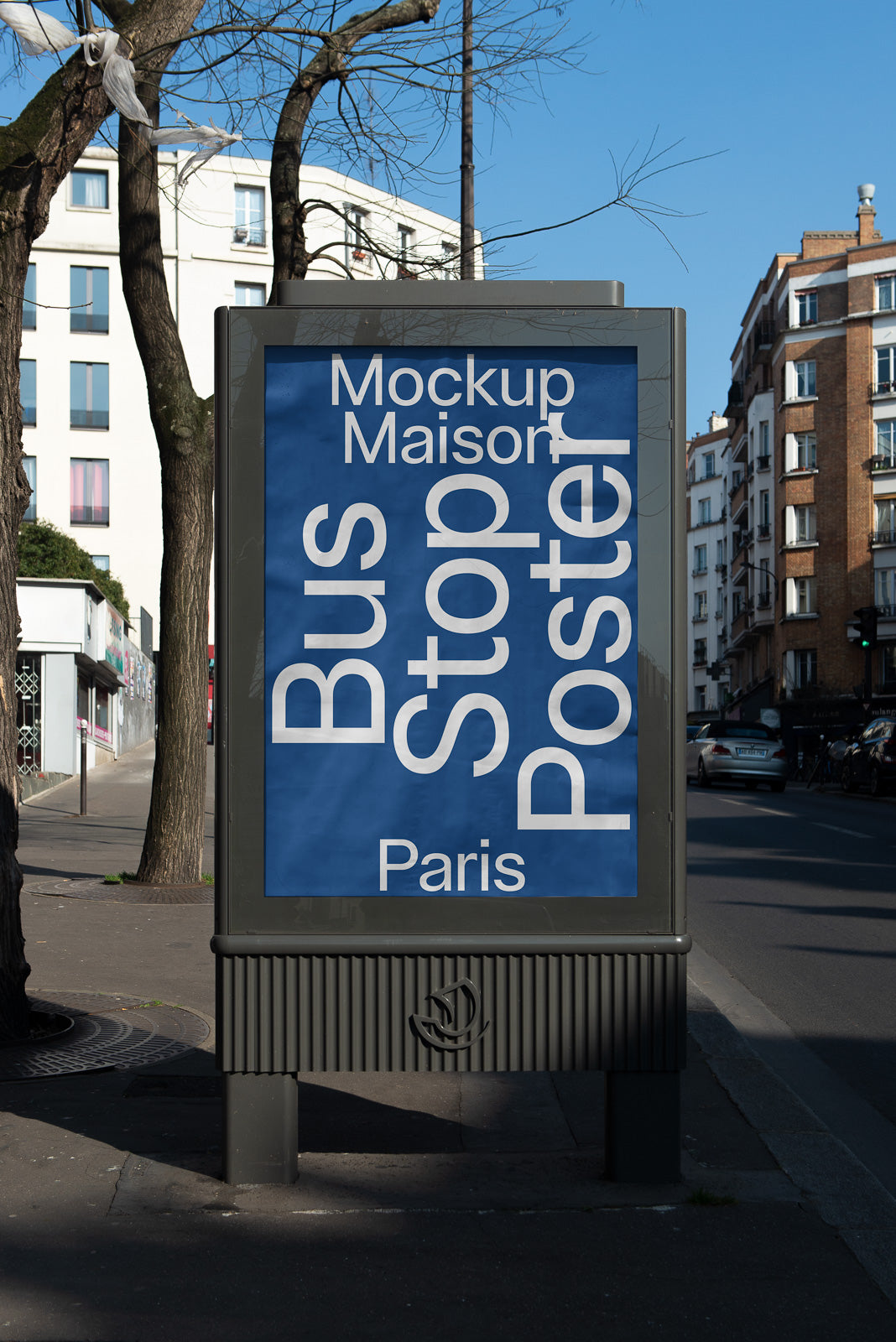 PSD mockup of a blue bus stop poster in an urban street setting with trees and buildings in the background.