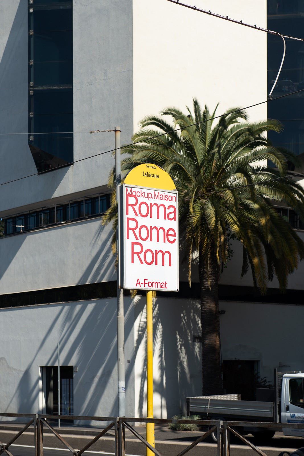 PSD mockup showcasing a bus stop with a modern urban background, featuring a yellow signpost with red and black text in different languages.