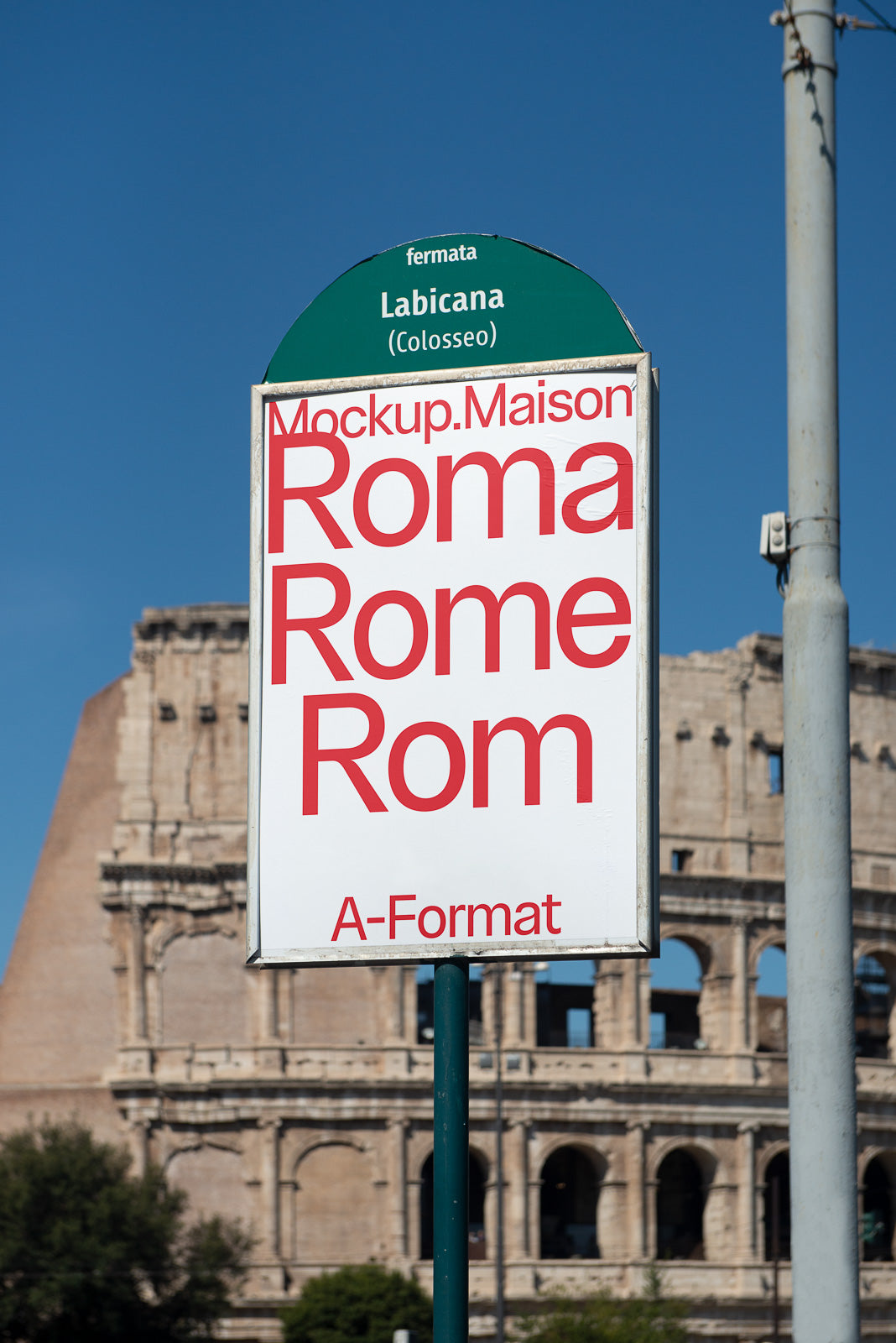 PSD mockup of a street sign displaying "Roma, Rome, Rom" set against the backdrop of the Colosseum under a clear blue sky.