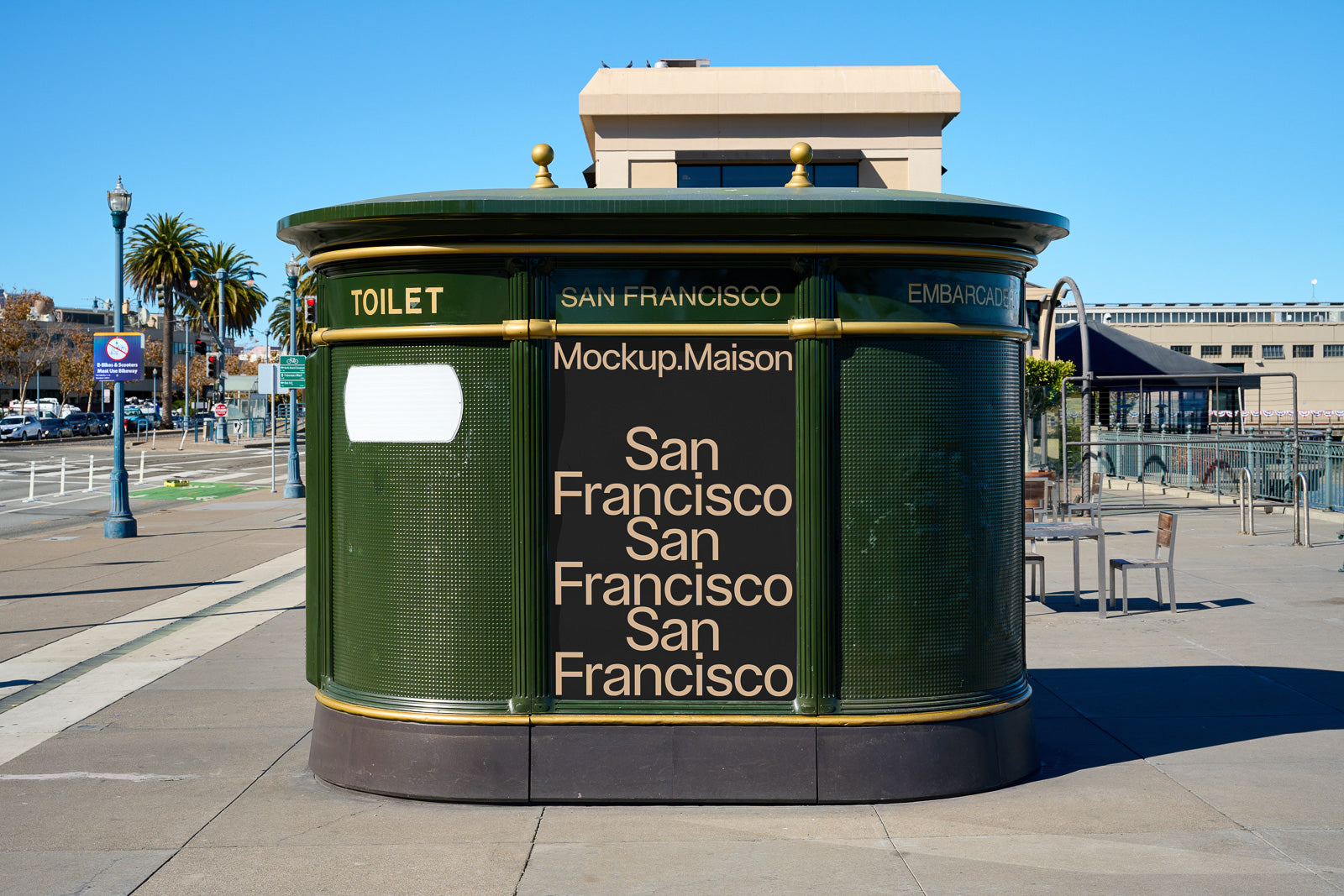 PSD mockup of a green cylindrical kiosk with "San Francisco" text design, set in an urban outdoor setting with blue sky and palm trees.