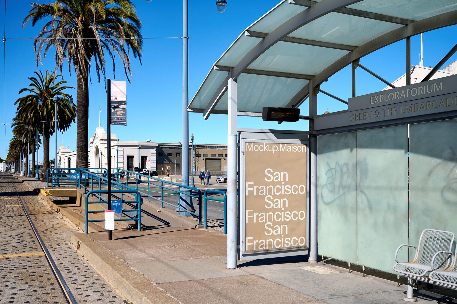 PSD mockup of a modern bus shelter in San Francisco featuring a large advertisement space with text, set against a backdrop of palm trees and a sunny street.