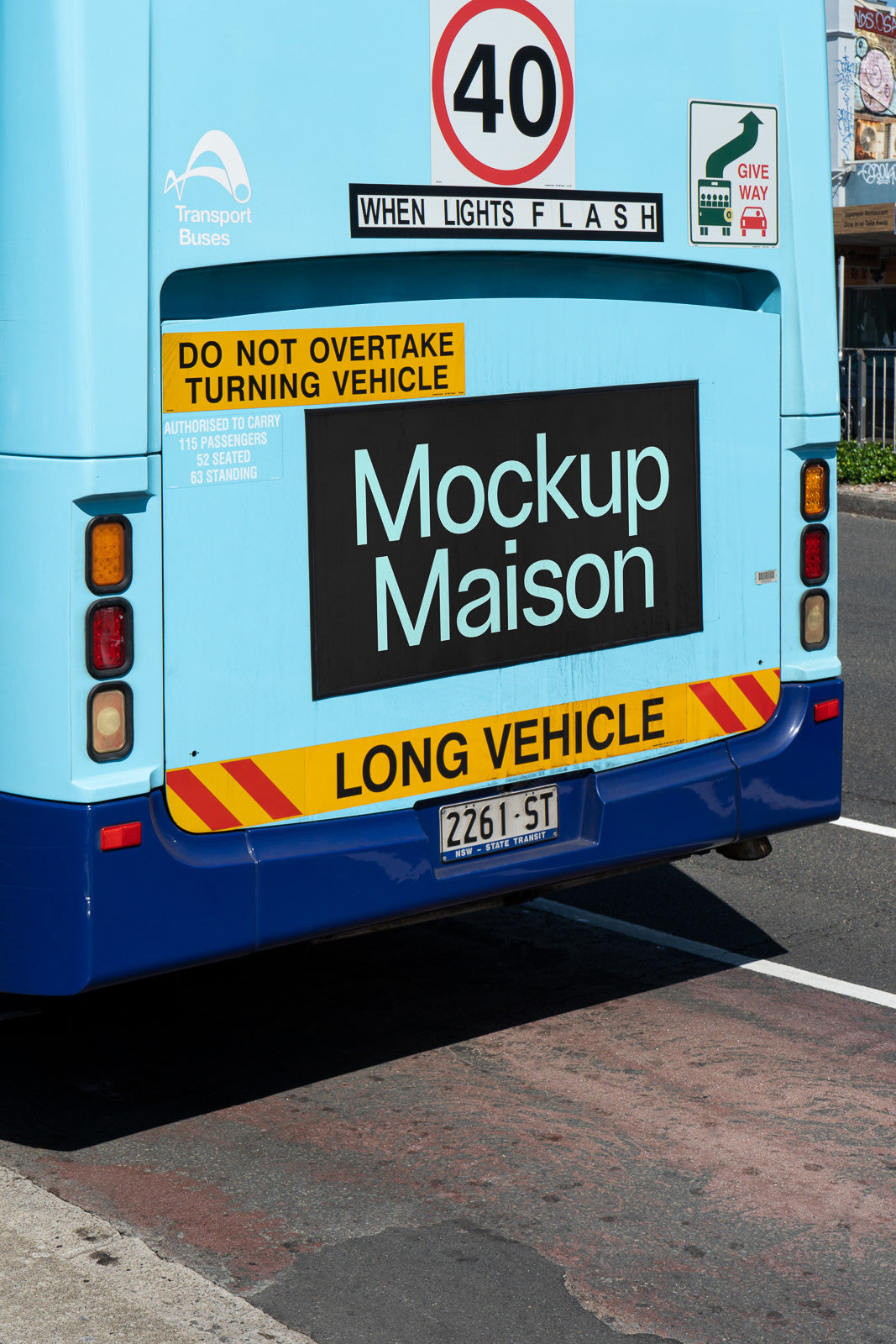 PSD mockup of a bus rear with safety and speed limit signs, highlighted by a prominent "Mockup Maison" ad, emphasizing caution messages.