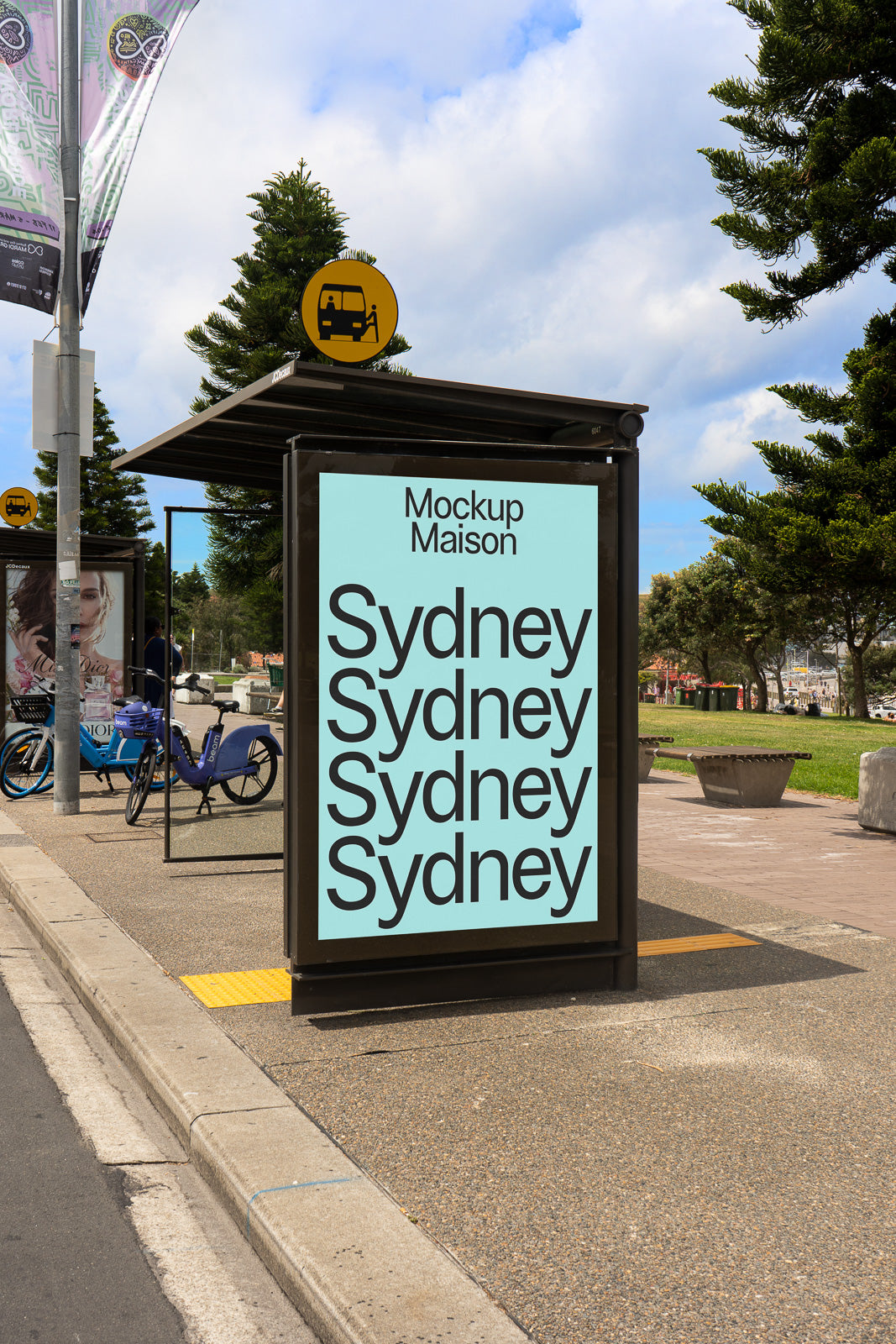 PSD mockup of a bus stop advertisement displaying the word "Sydney" in bold black letters repeated four times on a light blue background.