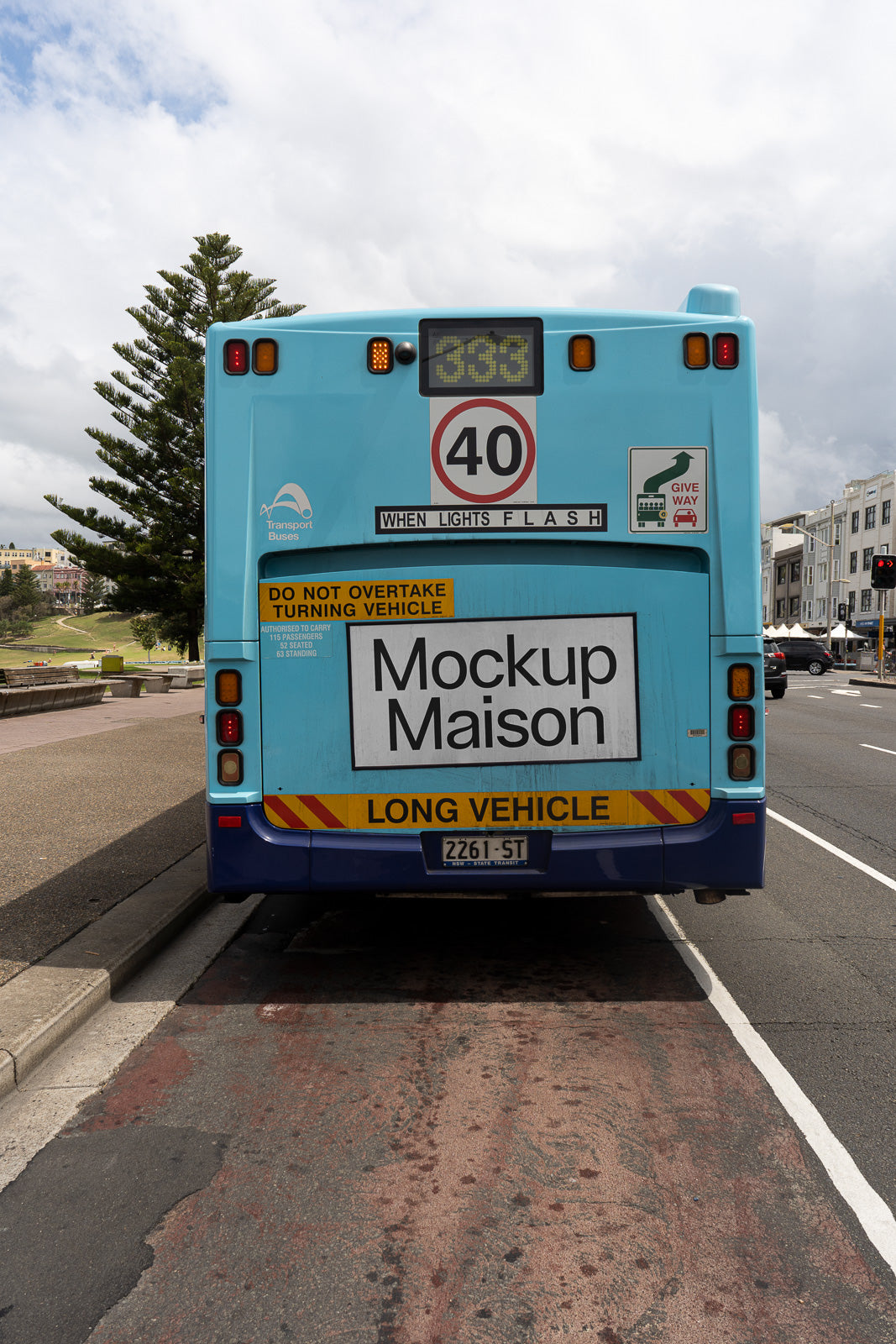PSD mockup of the rear view of a light blue bus parked on a street, displaying signage with various road safety warnings and instructions.