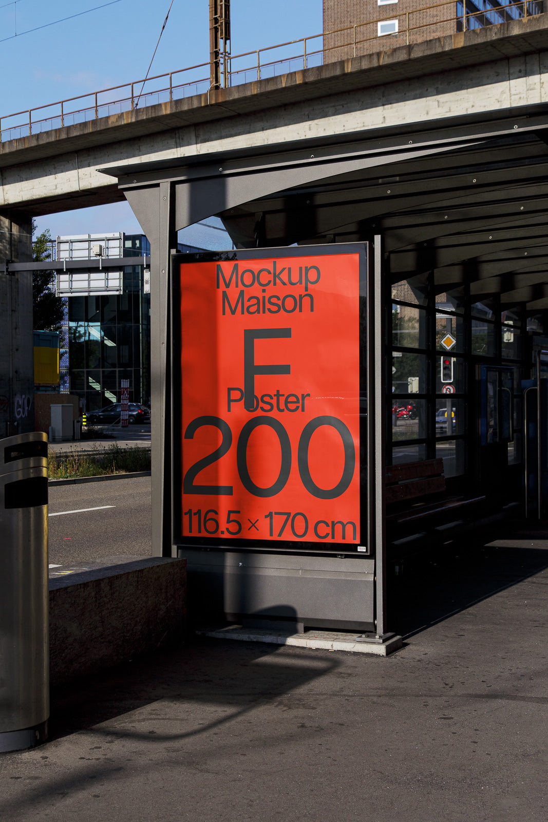 PSD mockup of a large red poster displayed at a bus shelter, featuring bold black text and measurements of 116.5 x 170 cm.