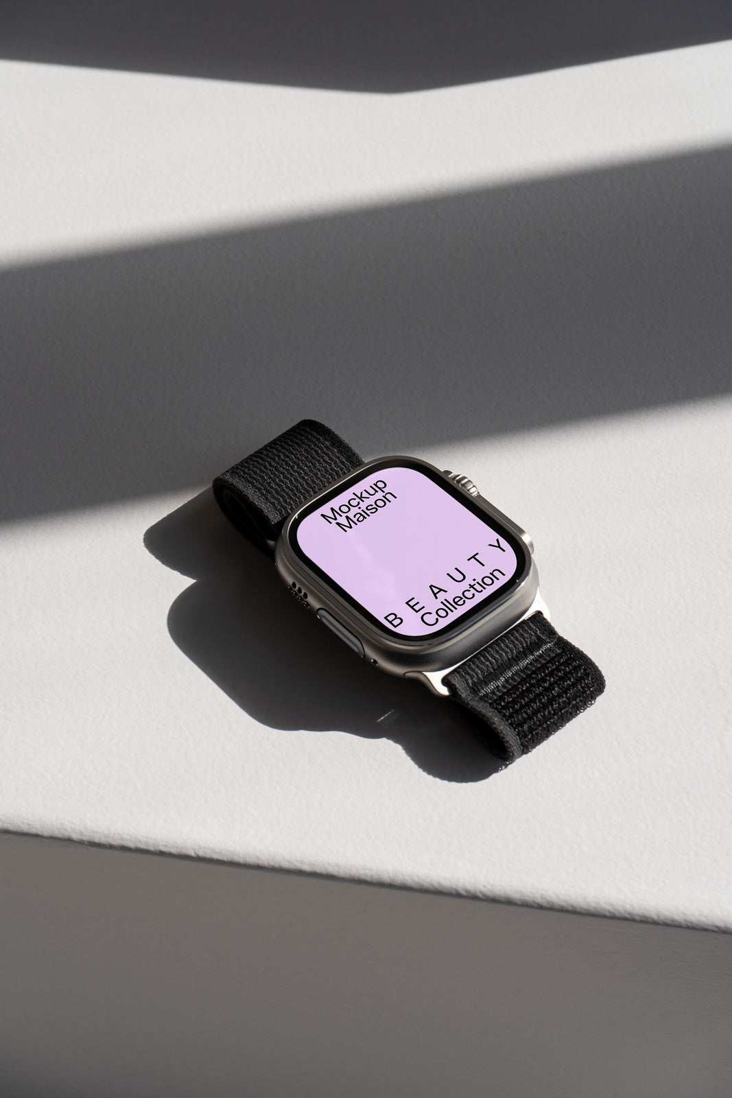 PSD mockup of a smartwatch with a black strap and a purple screen displaying the text "Mockup Maison Beauty Collection," placed on a white surface with shadows.