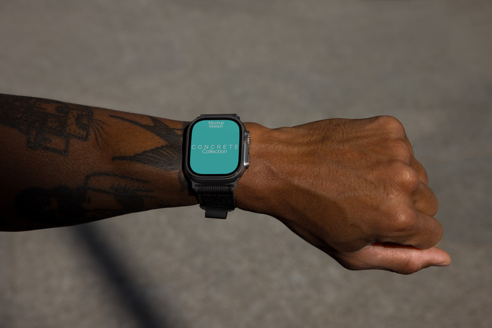 PSD mockup of a smartwatch on a tattooed wrist, displaying the text "Concrete Collection" on a teal screen, with a shadowed concrete background.