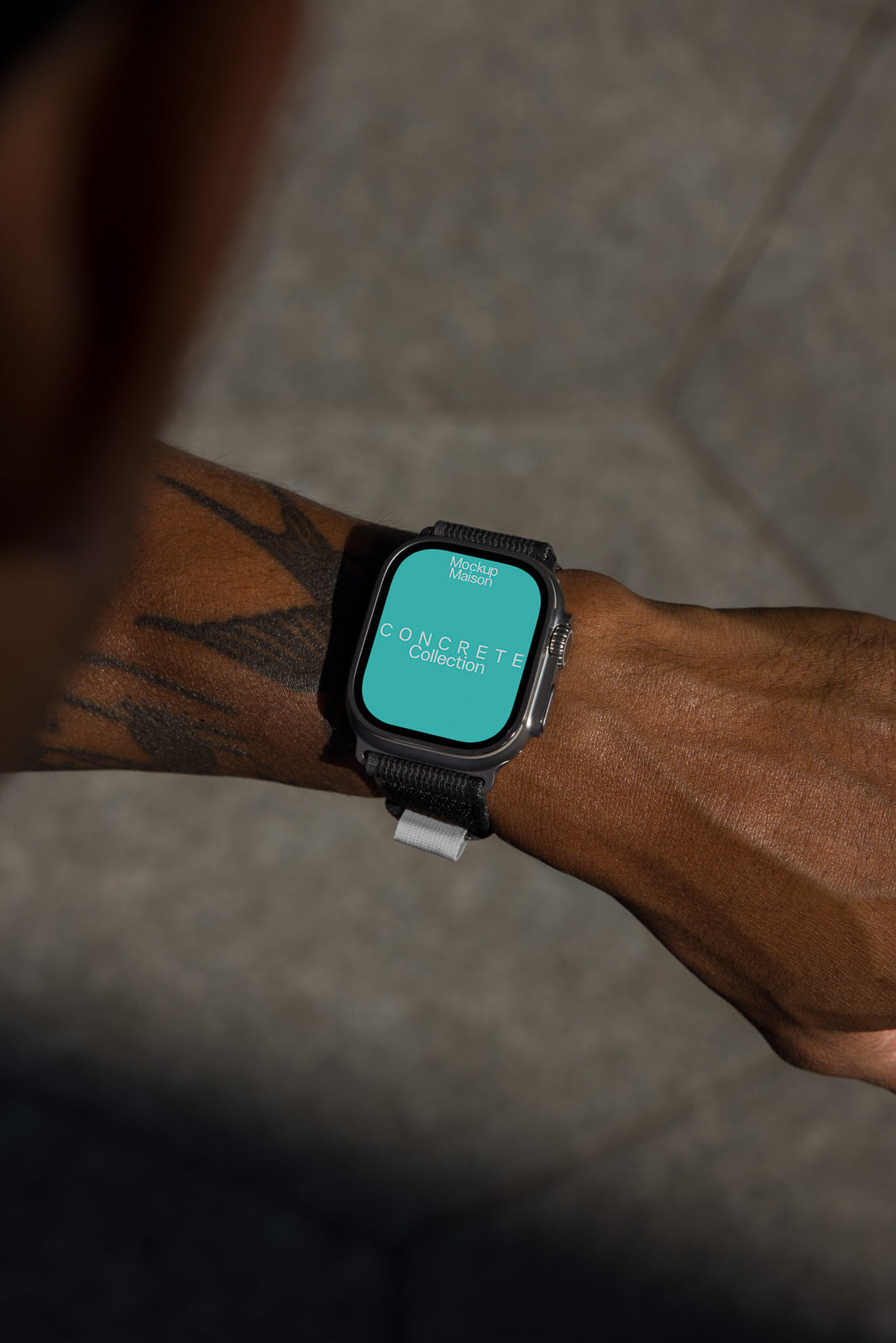 PSD mockup of a smartwatch on a person's wrist displaying a turquoise screen with "Concrete Collection" text. The watch has a black strap and metallic casing.