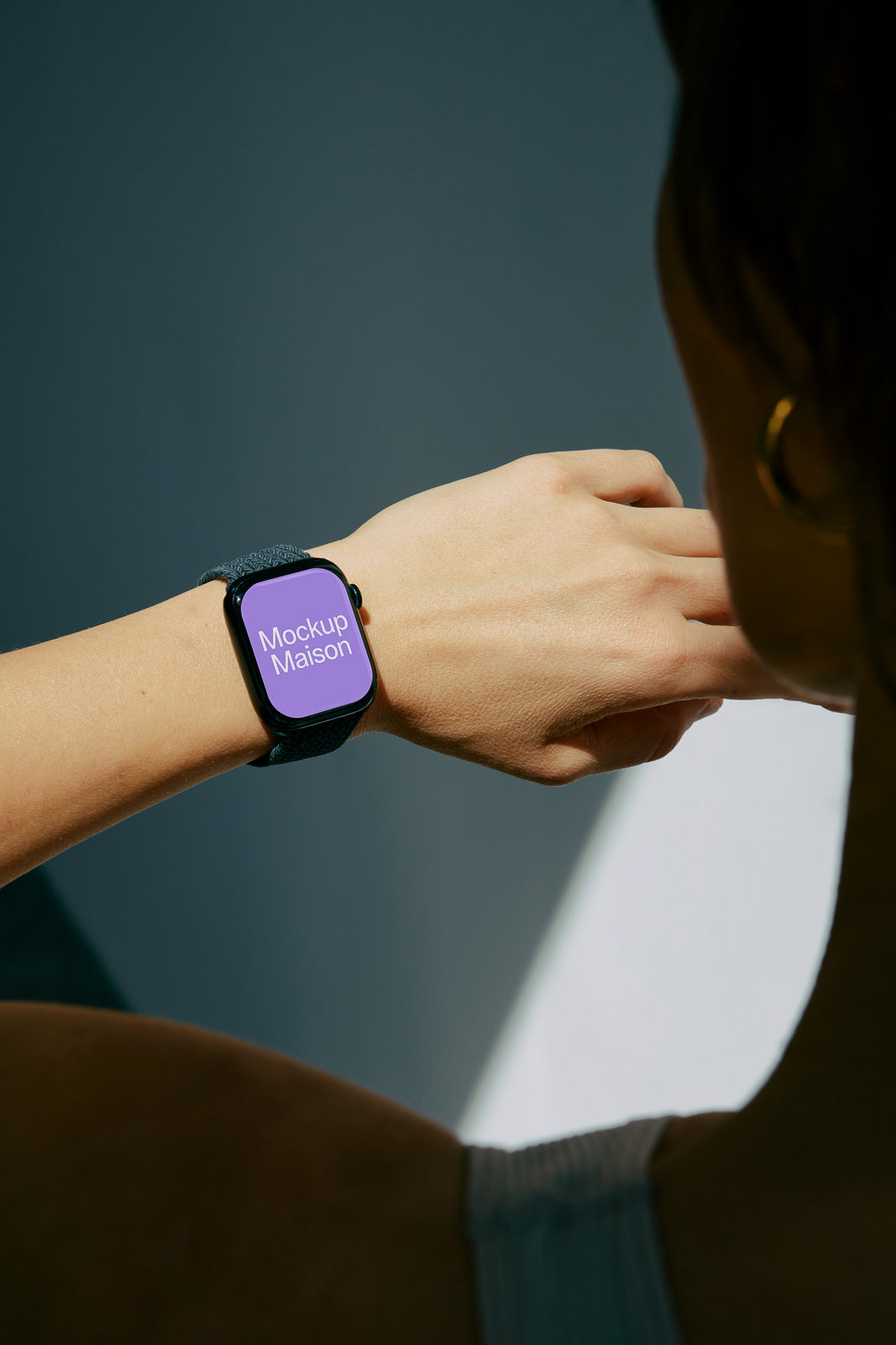 PSD mockup of a smart watch on a person's wrist, featuring a purple screen with the text "Mockup Maison" displayed.