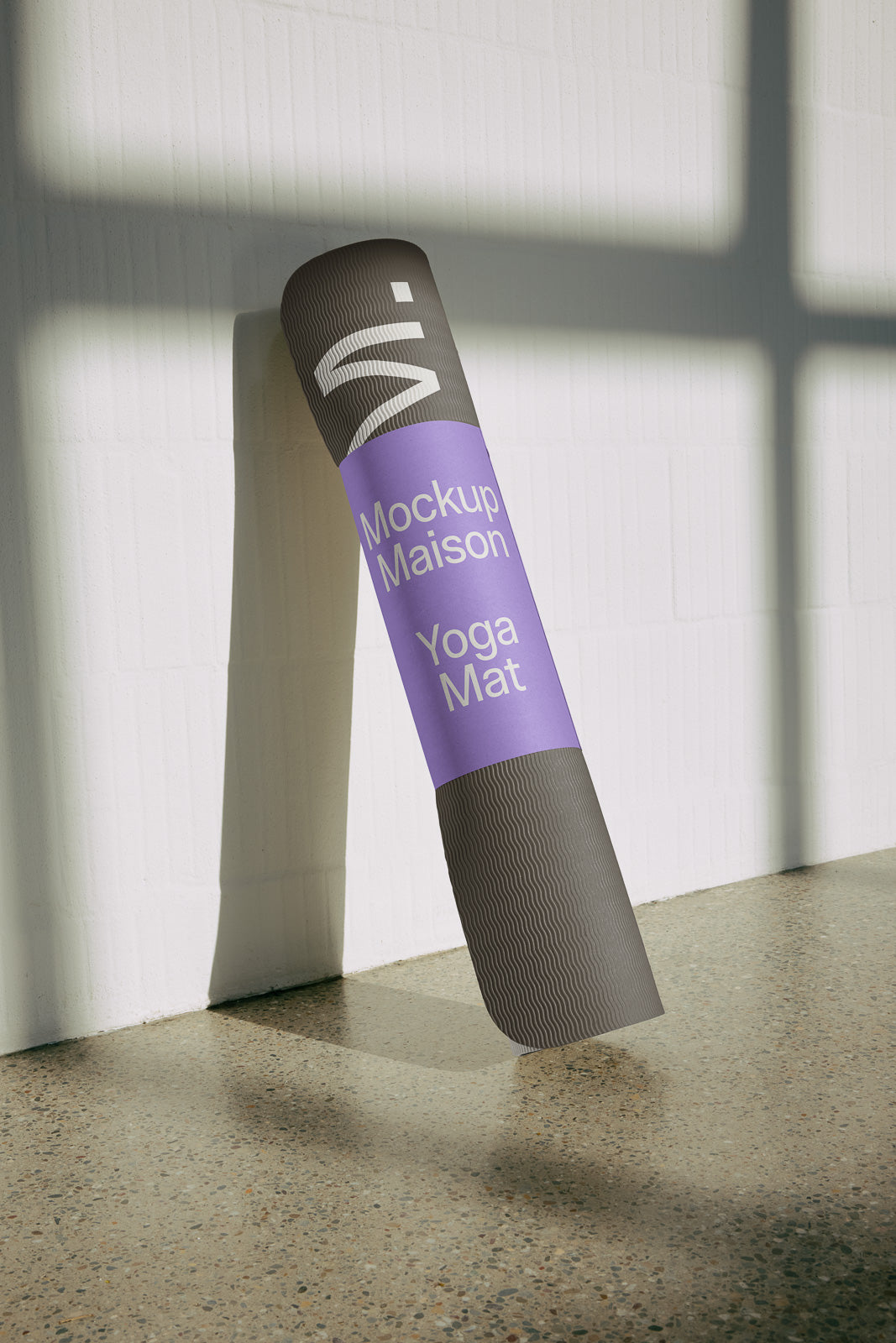 PSD mockup of a yoga mat with a textured design leaning against a white wall, casting a shadow on the polished floor.