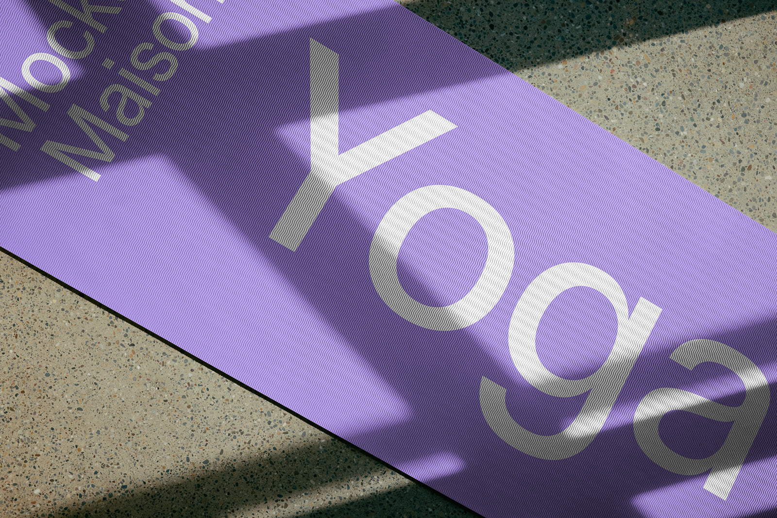 PSD mockup of a purple yoga mat on a textured stone-like surface with large text that reads "Yoga," partially obscured by shadows.